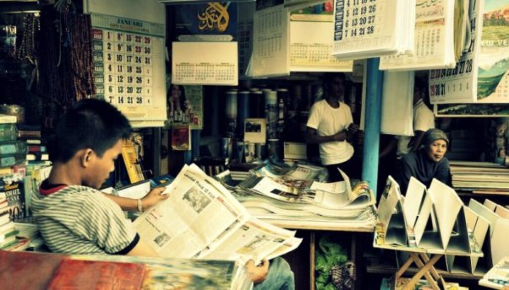 boy reading the paper learning new information