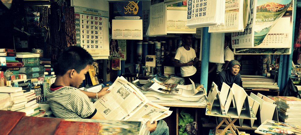 boy reading the paper learning new information