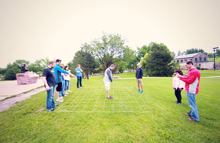 Standing in grid maze helping others during team building activity