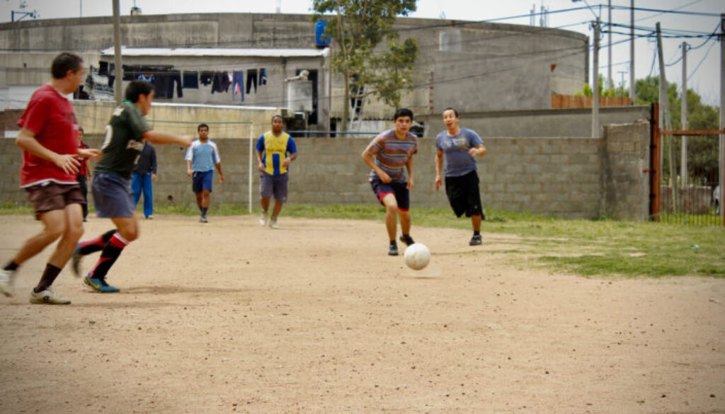 men-playing-soccer-in-dirt-field