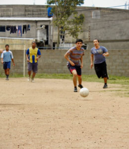 men-playing-soccer-in-dirt-field